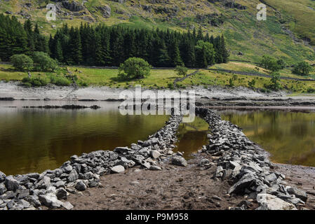 Haweswater, Cumbria Regno Unito. 19 luglio 2018. Una strada che attraversa la valle del villaggio ormai demolito di Mardale Green che è stata evacuata per far posto al bacino idrico di Haweswater che è stato riempito negli anni '1930 per aiutare l'acqua potabile da pompare a Manchester a oltre 80 miglia di distanza. Fig. Ripresa 19/07/2018. Credito: Interrompi stampa Media/Alamy Live News Foto Stock