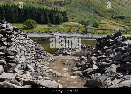 Haweswater, Cumbria Regno Unito. 19 luglio 2018. Una strada che attraversava quello che una volta era un gruppo di edifici nel villaggio ora demolito di Mardale Green che fu evacuato per far posto al bacino idrico di Haweswater che fu riempito negli anni '1930 per aiutare l'acqua potabile ad essere pompata a Manchester a oltre 80 miglia di distanza. Fig. Ripresa 19/07/2018. Credito: Interrompi stampa Media/Alamy Live News Foto Stock