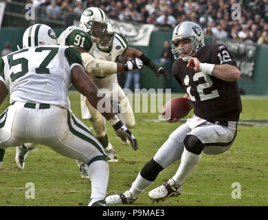 Oakland, la California, Stati Uniti d'America. Il 6 gennaio, 2002. I raider di Oakland quarterback Rich Gannon (12) tenta di ottenere intorno a New York getti backer linea Mo Lewis (57) Domenica, 6 gennaio 2002, a Oakland, in California. I getti sconfitto i raider 24-22. Credito: Al di Golub/ZUMA filo/Alamy Live News Foto Stock