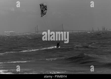 Kitesurfer infuria attraverso le onde Foto Stock