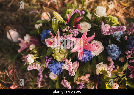 Decorazioni per matrimoni stile Boho con rosa e viola orchidee, rose, di edera e di mosti di uve Foto Stock