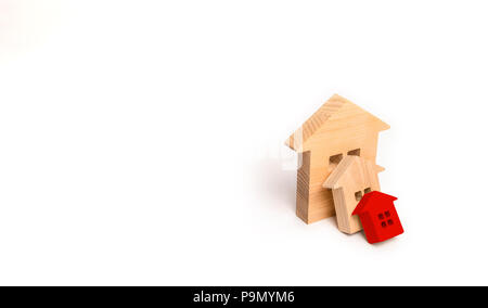 Piccole case in legno cadere sulla grande casa come un domino. Il concetto di acquisto immobiliare. Assicurazione e il rischio di investimento. Il calo dei prezzi nel reale es Foto Stock