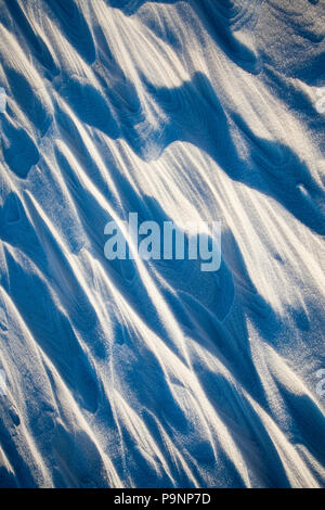 Neve fresca neve formata dalle dune e cumuli di neve, illuminato dal sole luminoso, ombre formata, close-up Foto Stock