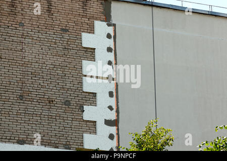 Isolamento del muro di mattoni della vecchia casa con l aiuto di bianco piastre di polistirene, e protetto da gesso, fotografia di close-up di sommità della BU Foto Stock