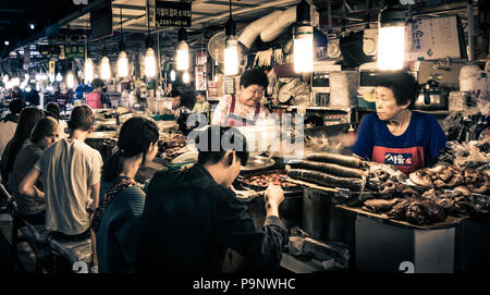 Seoul, Corea del Sud - 11 Maggio 2017: i clienti godono della coreana di cibi tradizionali al mercato GwangJang di notte. Foto Stock