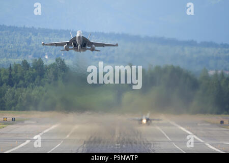 Un U.S Navy EA-18G Growler assegnato di Attacco Elettronico Squadron (VAQ) 139 dalla Naval Air Station Whidbey Island decolla da base comune Elmendorf-Richardson, Alaska Luglio 12, 2018. VAQ-139 è che operano al di fuori di JBER per fornire integrazione e supporto per la F-22 Raptor. (U.S. Air Force photo by Staff Sgt. James Richardson) Foto Stock