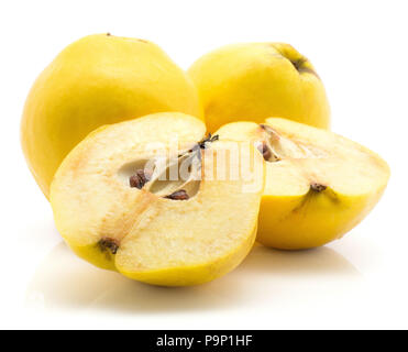 Due cotogne giallo con due metà isolato su sfondo bianco materie mature uno tagliato a metà con semi all'interno Foto Stock