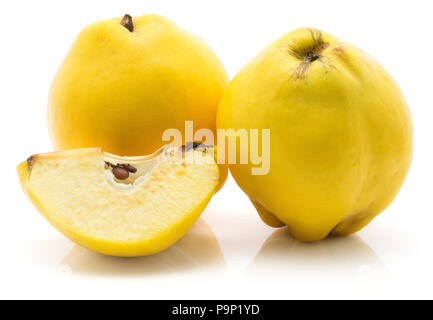 Due cotogne giallo con una fetta con semi isolato su sfondo bianco materie mature Foto Stock