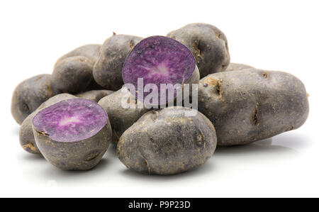 Patate Vitelotte isolati su sfondo bianco mucchio di affettato e tutta la porpora Foto Stock