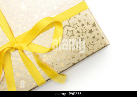 Presente box legati dal nastro giallo e decorato da un sacco di stelle luccicanti isolati su sfondo bianco Foto Stock