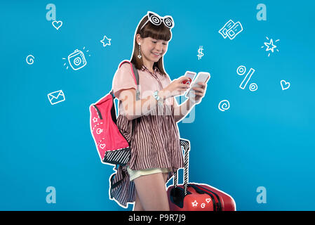 Ragazza positivo mettere il denaro sul suo conto prima di viaggiare Foto Stock