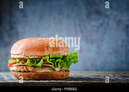 Appetitosi hamburger fatti in casa con pollo e insalata su sfondo scuro Foto Stock