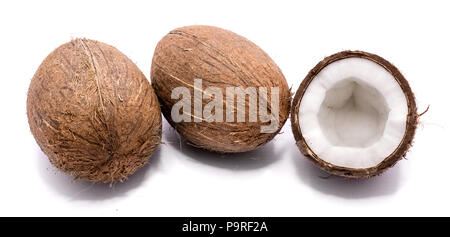 Due interi noci di cocco e una noce di cocco incrinato metà isolato su sfondo bianco Foto Stock