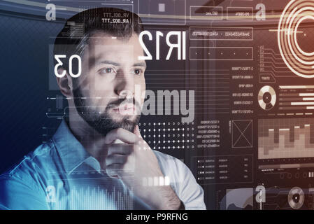 Risultato inaspettato. Programmatore attento pensieroso guardando lo schermo mentre si verifica il suo nuovo potente programma Foto Stock