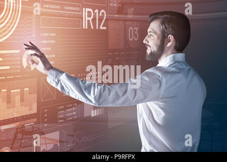 Programmatore emotiva. Allegro giovane programmatore intelligente sorridente e sentirsi felice mentre si lavora nel suo comodo ufficio Foto Stock