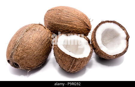 Due interi noci di cocco e rotto due metà di noce di cocco isolati su sfondo bianco Foto Stock