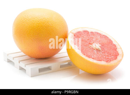 Pompelmo rosso su un pallet isolati su sfondo bianco di una intera e una metà a fette Foto Stock