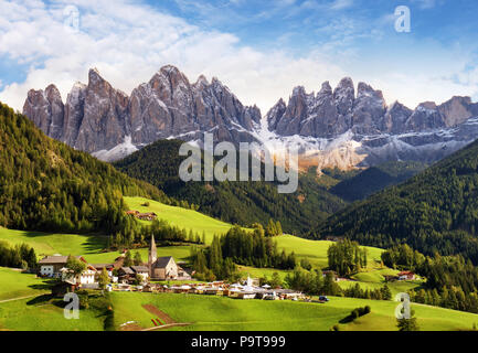 Val di Funes, Trentino Alto Adige, Italia. Il grande colori autunnali brilla sotto il sole in ritardo con le Odle sullo sfondo e Santa Magdalena Village Foto Stock