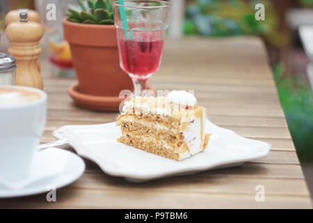 Il pezzo di torta sul tavolo della terrazza estiva in cafe, pic-nic, set table Foto Stock