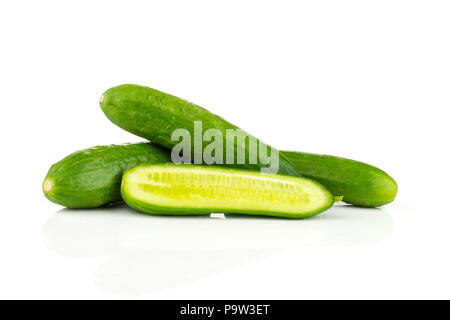Tre fresco verde mini cetrioli e una sezione a metà isolato su sfondo bianco Foto Stock