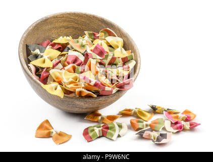 Farfalle di pasta con verdure in e nei pressi di una ciotola di legno isolato su sfondo bianco materie classico italiano tradizionale Foto Stock