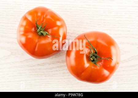 Due di pomodoro rosso isolato su grigio Sfondo legno vista superiore Foto Stock