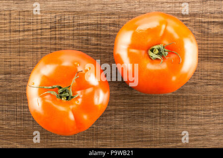 Due di pomodoro rosso isolato su legno marrone sfondo vista superiore Foto Stock