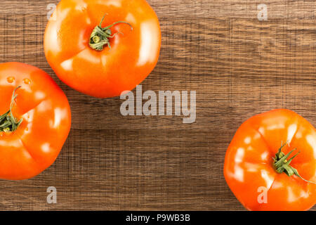 3 pomodoro rosso vista superiore isolata marrone su uno sfondo di legno Foto Stock