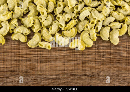 Pasta spinaci creste di gallo flatlay isolate su legno marrone sfondo vista superiore materie Foto Stock