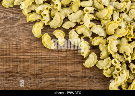 Pasta spinaci creste di gallo flatlay grezzo isolato su legno marrone sfondo vista superiore Foto Stock