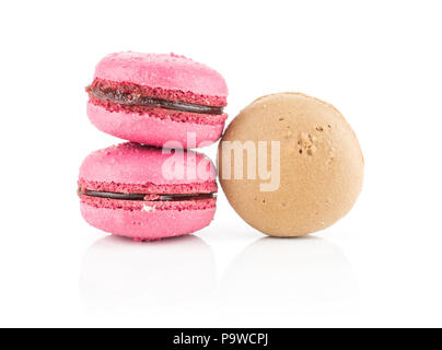 Tre francesi macarons un cioccolato e due con lampone isolati su sfondo bianco Foto Stock