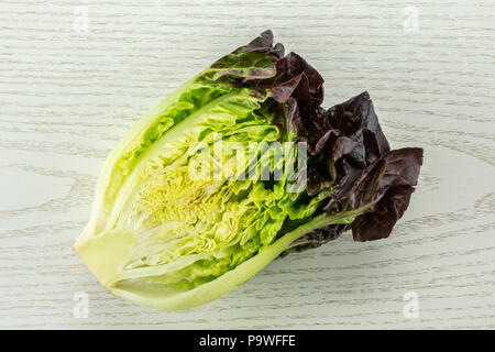 Una metà del fresco verde lattuga rosso piccolo gioiello varietà flatlay su legno grigio Foto Stock