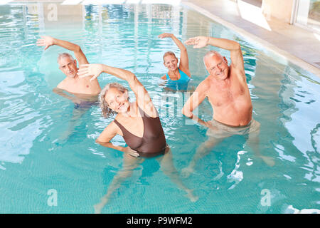 Gli anziani rendono sano stretching in un corso per acquagym Foto Stock