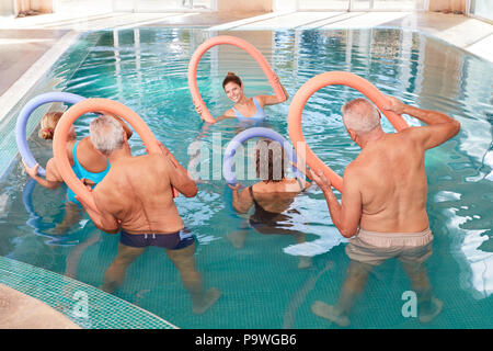 Gruppo di anziani fanno rehab torna la formazione in un centro benessere piscina Foto Stock