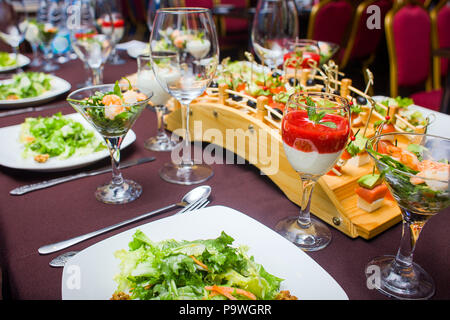 La tabella è prevista per la celebrazione, ci sono gli occhiali e insalata un Foto Stock