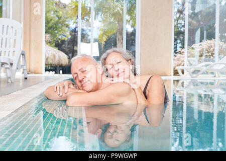 Coppia senior si rilassa a bordo della piscina in piscina a spa hotel Foto Stock