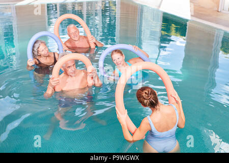 Senior Group sta facendo una sana ginnastica in acqua come rehab in piscina Foto Stock