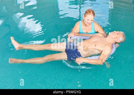 Gli anziani facendo esercizi yoga nella piscina di idroterapia Foto Stock