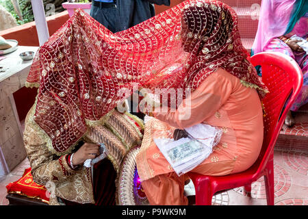 Un matrimonio tradizionale nella provincia indiana. Lo sposo accetta doni, desideri e benedizioni da sua madre. India Giugno 2018 Foto Stock