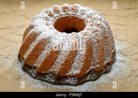 Fatto in casa appena sfornato tutto il Marmo torta ricoperta con lo zucchero in polvere sulla carta. Foto Stock