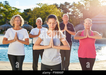 Gruppo di anziani insieme nella classe di yoga presso la piscina termale è fare un esercizio Foto Stock