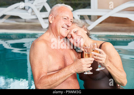 Felice coppia senior in amore la tostatura champagne presso il centro termale Foto Stock