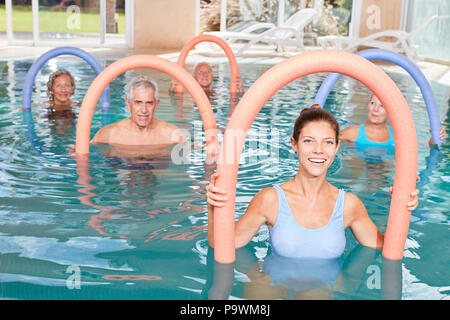 Gruppo Senior in rehab facendo esercizi di idroterapia in piscina Foto Stock