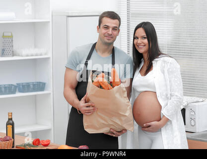 Il marito e la moglie incinta tenendo un pacchetto di baguette Foto Stock