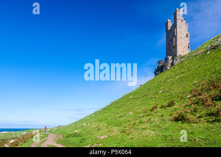 Le rovine del castello di Dunstanburgh del XIV secolo sul sentiero costiero del Northumberland, Inghilterra Foto Stock