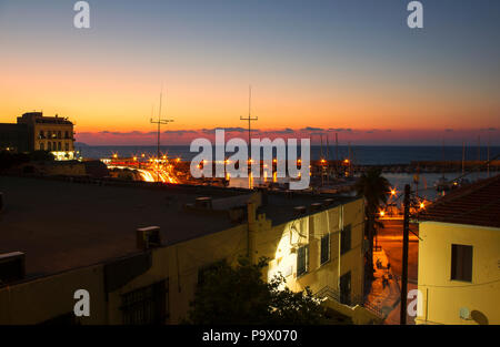 Paesaggio notturno presso il porto di Heraklion, con luci radiante e il tramonto del sole estivo (Grecia) Foto Stock