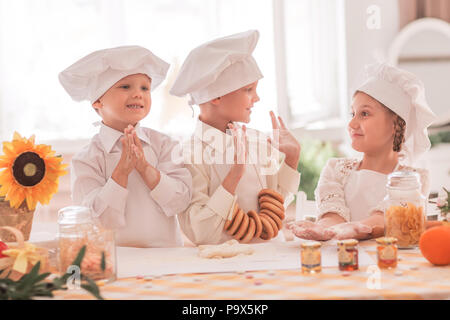 Felici i bambini piccoli nella forma di uno chef per preparare deliziose Foto Stock