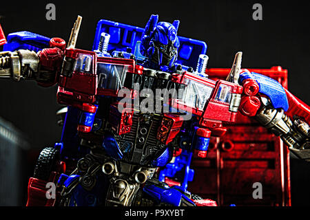 Optimus Prime in combattimento tra contenitori in un dock bay. Foto Stock