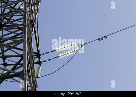 Pali metallici di linee ad alta tensione e i fili per la trasmissione di energia elettrica, contro un cielo blu background closeup Foto Stock