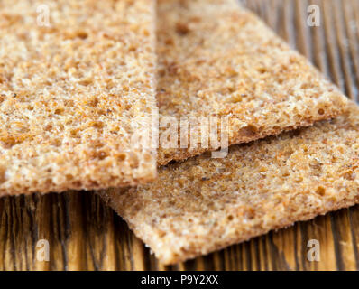 Sottile pane secco da farina di segale, pronto a mangiare, closeup pasto su di un tavolo di legno Foto Stock